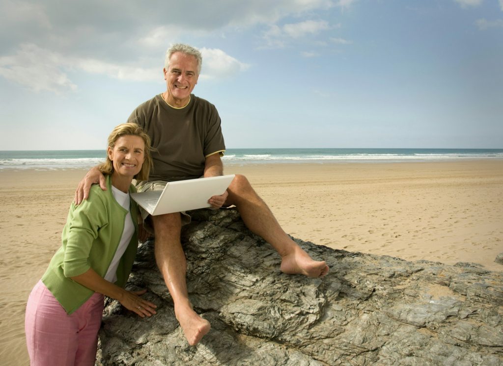 Couple on beach with laptop computer